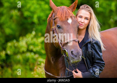 Belle femme souriante avec son cheval arabe dans le domaine Banque D'Images