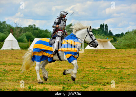 Cité médiévale des chevaliers en armure de plaque complète avec sward galoper à cheval Banque D'Images