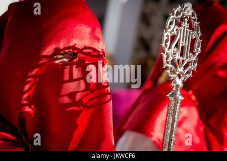 Un pénitent de notre père miséricordieux Jésus détient une fraternité crosier pendant la procession du dimanche des rameaux de l'inland village de sierra de yeguas. sierra de yeguas est un village d'environ 3 500 habitants, c'est l'économie est principalement basée sur le secteur agricole puisqu'il n'est loin de la zone touristique de la province de Malaga. le dimanche des rameaux, le constituated récemment confrérie de notre père Jésus grâce à des parades, en milieu d'après-midi, la procession est un événement familial collectif où grandi et les enfants participent actievley et célébrer l'arrivée de Jésus à Jérusalem. Banque D'Images