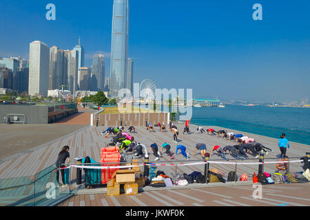 HONG KONG, CHINE - le 26 janvier 2017 : foule de personnes faisant de l'exercice de Tai Chi le matin, avec un downton de la ville de Hong Kong comme arrière-plan. Banque D'Images