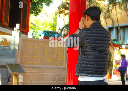 HONG KONG, CHINE - le 22 janvier 2017 : l'homme de prier dans de d'un signe d'information écrite sur un mur en bois avec des lettres jaunes dans une tour de Victoria Peak Banque D'Images