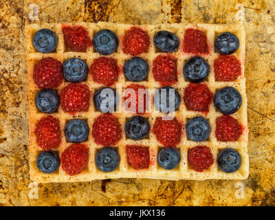 Les framboises et les bleuets sur une gaufre grillée sur un plateau de four en détresse Banque D'Images