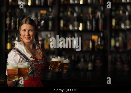 Oktoberfest joli blond woman holding verres en bar Banque D'Images