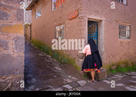 L'île de Taquile, PÉROU - CIRCA AVRIL 2014 : Femme dans rue typique de l'île de Taquile, dans le lac Titicaca, au Pérou. Banque D'Images