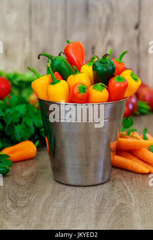 Poivrons jaunes rouge dans un seau un assortiment de Poivrons et piments dans un seau en métal avec des gouttelettes d'eau vertical format Banque D'Images