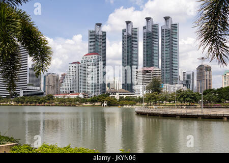 Skyscapers s'élevant au-dessus du lac dans le parc Benjakiti, Bangkok, Thaïlande Banque D'Images