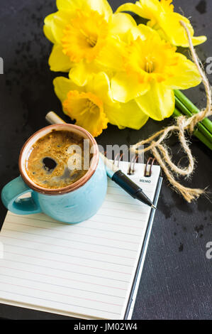 Grande tasse de café et des jonquilles jaune vif sur la table en bois rustique avec copyspace Banque D'Images