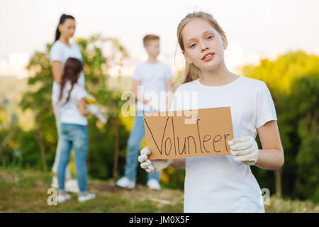 C'est très facile. Certain girl holding plaque avec devise dans les deux mains et en gardant la bouche ouverte tout en se posant sur l'appareil photo Banque D'Images