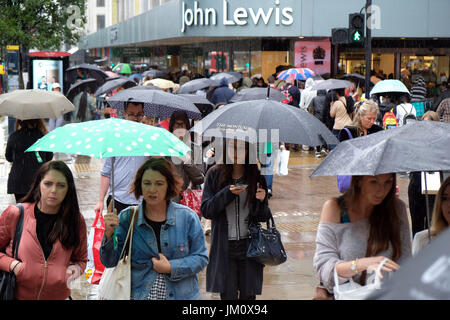 Pix : montre de l'été humide à Londres. Battues de pluie shopper dans Oxford Street près de John Lewis store. Pic par Gavin Rodgers/Pixel 8000 Ltd Banque D'Images