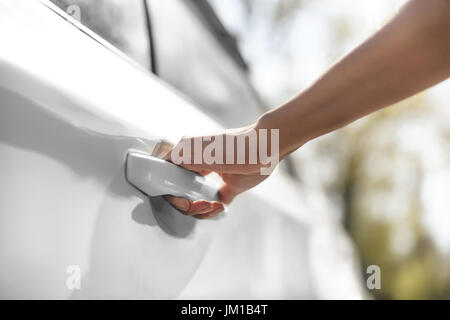 Vue partielle de l'ouverture de porte de voiture femme sur le parking Banque D'Images