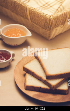 Toast avec confiture de fraise et d'orange sur une assiette sur la table. Banque D'Images