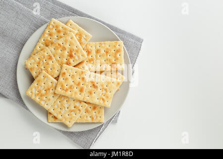 Libre d'un snack-plaque. Pile de crackers sur plaque gris et gris sur fond blanc serviette Banque D'Images