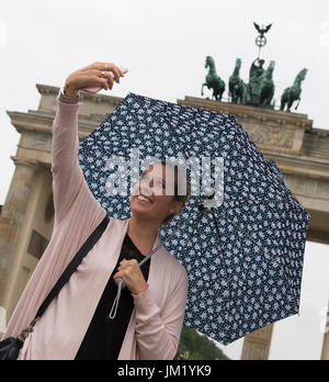 Gina (23) de Cologne prend un en face de l'selfies porte de Brandebourg à Berlin, Allemagne, 25 juillet 2017. Photo : Paul Zinken/dpa Banque D'Images