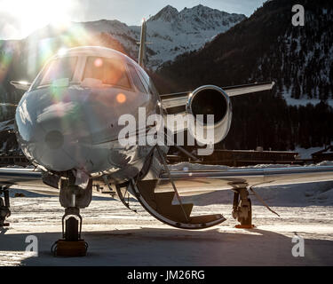 Garée à l'aéroport de Samedan Engadin sur snow park à la dernière lumière du jour ! Banque D'Images
