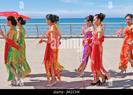 Les femmes en costume traditionnel chinois transportant des parasols sur la promenade de Blackpool pendant le carnaval international Banque D'Images