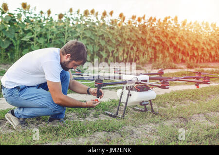 Jeune ingénieur de drone de surveillance de la préparation dans le champ. Banque D'Images