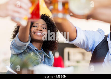 Les amis clinking glasses avec boissons au restaurant Banque D'Images