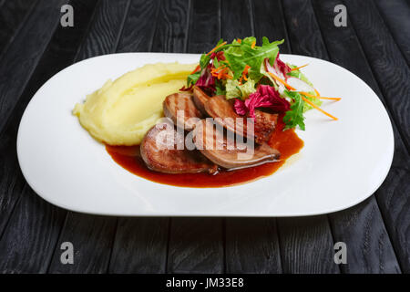 La langue de boeuf avec purée de pommes de terre et salade avec sauce aux airelles Banque D'Images