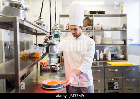 Heureux homme, la cuisson à chef de cuisine restaurant Banque D'Images