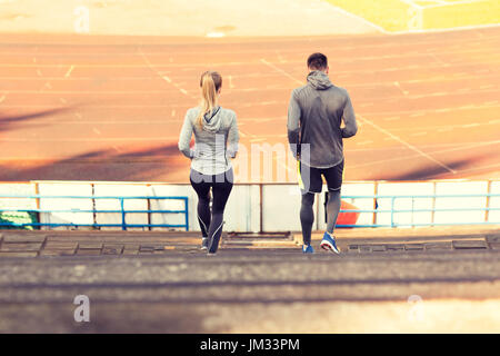 Couple running en bas sur stadium Banque D'Images