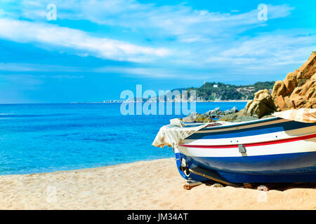 Un vieux bateau de pêche échoué dans la calme plage Platja de Sa Caleta à Lloret de Mar, sur la Costa Brava, Espagne Banque D'Images