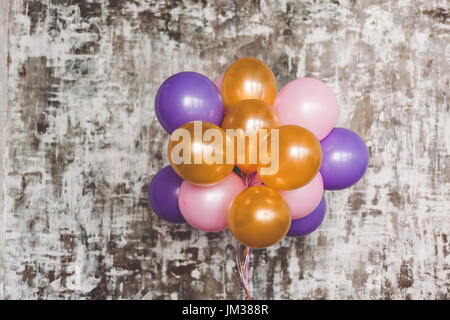 Bouquet de ballons lumineux contre un mur texturé. Copy space Banque D'Images