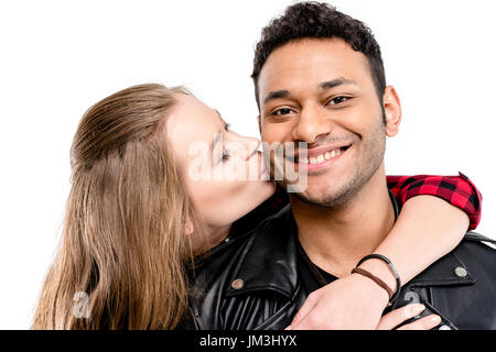 Young blonde woman kissing smiling man en blouson de cuir isolated on white Banque D'Images