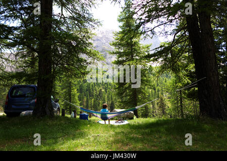 Jeune garçon se détendre dans un hamac dans les bois à col Col d'Izoard, Alpes, France. Banque D'Images