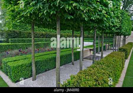 Un jardin classique avec une avenue d'if, case et charme menant à une pièce d'eau et de la sculpture Banque D'Images