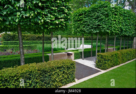 Un jardin classique avec une avenue d'if, case et charme menant à une pièce d'eau et de la sculpture Banque D'Images