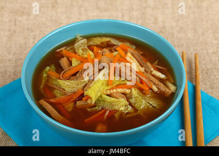 Partie de la soupe miso ramen nouilles asiatiques avec viande de boeuf et de légumes dans le bol bleu en céramique avec des baguettes de table, Close up, high angle view Banque D'Images