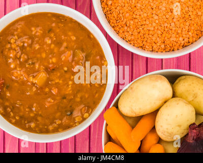 Bol de soupe de lentilles et chunky bacon contre un fond de bois de rose Banque D'Images