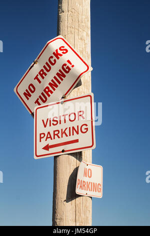 Parking visiteurs, pas de parking et pas de camion tournant signes sur poteau en bois Banque D'Images