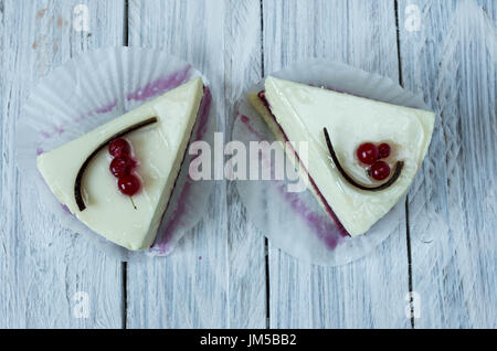 Gâteau au fromage blanc avec groseille. Mise à plat en bois blanc arrière-plan. Banque D'Images