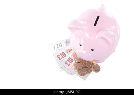 Concept d'économie d'argent en espèces avec petit mignon pink piggy bank et quelques pièces et billets GBP, vues de dessus isolé sur fond blanc avec l'exemplaire s Banque D'Images
