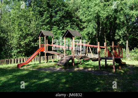 Aire de jeux en bois fixés avec des diapositives / vieux jeux pour enfants parmi les arbres Banque D'Images