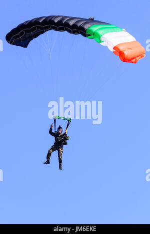 Parachuter de l'Irish Army Black Knights parachute display team arrive sur terre. Banque D'Images