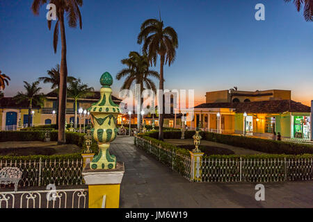 Palmiers et de bâtiments historiques sur la Plaza Mayor au crépuscule - Trinidad, Cuba Banque D'Images