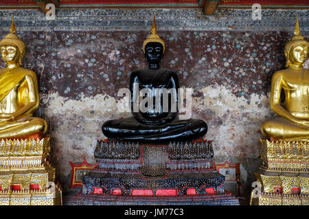 Statue de Bouddha noir assis dans le couloir extérieur de Wat Suthat Thepwararam, un temple bouddhiste à Bangkok, Thaïlande. Banque D'Images