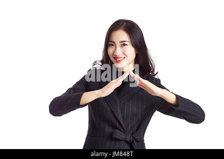 Young Asian agent immobilier montrant un signe de toit, studio shot, isolé sur fond blanc. Banque D'Images