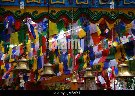 Les drapeaux de prières et de cloches en laiton à l'entrée du temple sur la colline de l'Observatoire Mahakal, Darjeeling, Inde, West-Bengal Banque D'Images