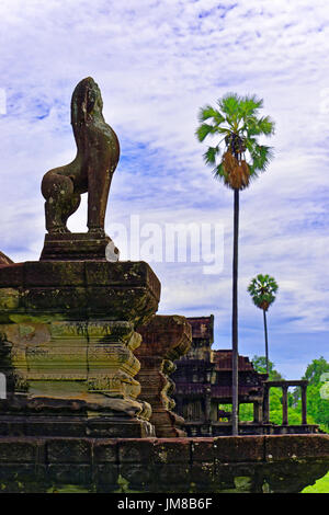 Cambodge Angkor Wat temple interne complexe et palmiers gardée par un lion statue Banque D'Images