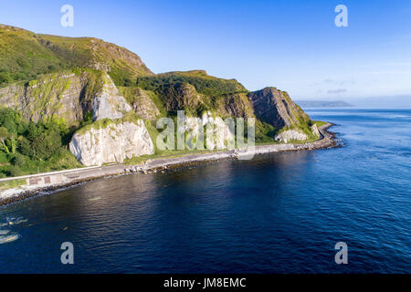 La côte orientale de l'Irlande du Nord avec des falaises et route côtière d'Antrim, alias Causeway Route Côtière. Vue aérienne au lever du soleil Banque D'Images