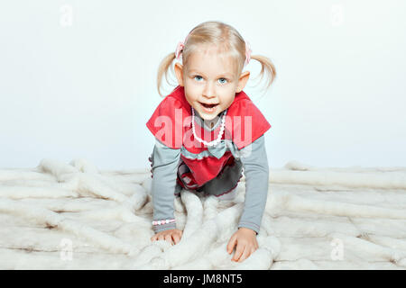 Bébé fille blonde rampent sur plateau. Jeune fille ouvrit la bouche Banque D'Images