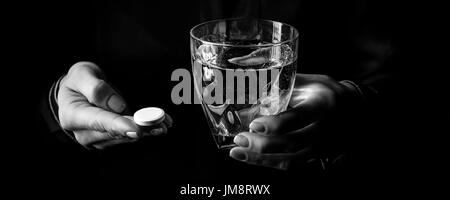 Black Mania. female hands isolated on black montrant comprimé et verre de l'eau Banque D'Images