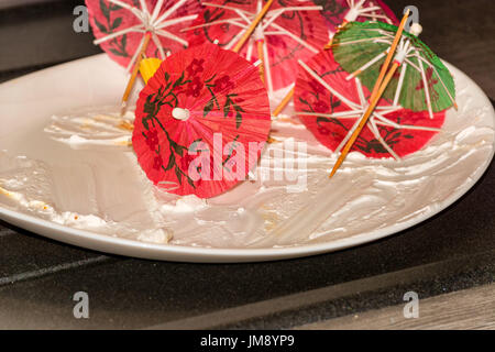 Assiette Dessert blanche vide, plaque sur une plaque de cuisine avec reste de matériau de décoration de gâteau. Banque D'Images
