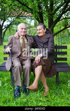 Plus de 80 ans mignon vieux couple posant pour un portrait dans leur jardin. Concept de l'amour pour toujours. Banque D'Images