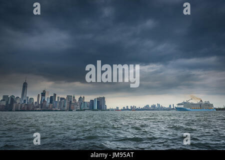 Les nuages de tempête tonitruant sombre linceul sur le Lower Manhattan skyline et un passager, bateau de croisière sur le fleuve Hudson à New York, New York, USA Banque D'Images