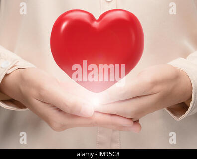 Main tenant le rendu 3d red heart Banque D'Images