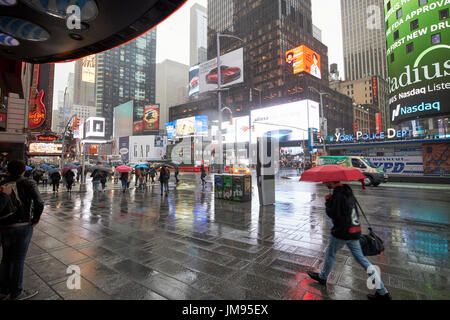 Sous l'auvent permanent regarder les gens marcher passé sous la pluie New York USA Banque D'Images